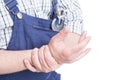 Close-up of repairman holdig his wrist in pain