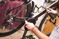 Close up of repairman is lubricate the bike chain in workshop. High quality photo