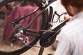 Close up of repairman is holding spray lubricant in his hand to lubricate the bike chain