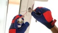 Repairman using lubricate in spray can for lock of plastic window