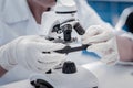 Close up of researcher placing sample under microscope Royalty Free Stock Photo