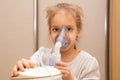 Close up. Respiratory diseases. A 5-year-old child inhales medication using a nebulizer. Therapy of coronavirus