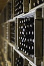 Close up of resting wine bottles stacked on wooden racks