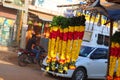 Close up of retail flower garlands shop with blur running car on road backgrounds, street flower market Royalty Free Stock Photo