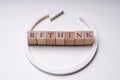 Wooden Blocks With Rethink Word And Arrow Over White Background