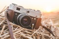 Close-up, retro camera lies on a haystack in a field against the backdrop of a sunset sun Royalty Free Stock Photo