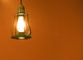 Close up retro hanging light lamp, bulb decorative in orange background Royalty Free Stock Photo