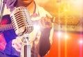 Close up retro microphone with musician playing acoustic guitar on band Royalty Free Stock Photo