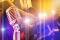 Close up retro microphone with musician playing acoustic guitar on band Royalty Free Stock Photo