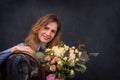 Close up retrostyle portrait of the young woman with a bouquet o