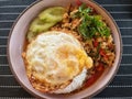 Close-up of rice topped with the fried egg and stir-fried minced pork with chili and Thai basil leaves Royalty Free Stock Photo