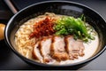 close-up of rich and creamy bowl of tonkotsu ramen with noodles, crispy pork belly, and green onions