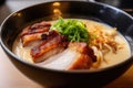 close-up of rich and creamy bowl of tonkotsu ramen with noodles, crispy pork belly, and green onions