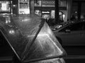 Close-up of a rickshaw along a city centre street at night in London, England. Abstract street photo in black and white.