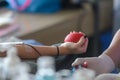 Close up right arm of asian female receiving blood and holding rubber ball in hand. Healthcare and charity. Transfusion blood dona