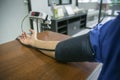 Close up a right hand using a blood pressure on wooden table at hospital,daylight,selective focus,filtered image Royalty Free Stock Photo