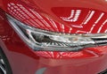 Close up of right headlight of the red car.