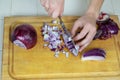 Two hands close up dicing red onion on cutting board Royalty Free Stock Photo