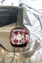 Close-up of right rear light of beige SUV Renault Duster in showroom of the Renault dealership. Renault showroom