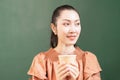 Close-up right side of beautiful Asian woman customer happy to drink hot coffee and looks at left side in coffee bar