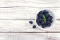 Close up of ripe blackberries in a white ceramic bowl over rustic wooden background