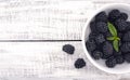 Close up of ripe blackberries in a white ceramic bowl over rustic wooden background Royalty Free Stock Photo