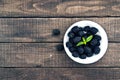 Close up of ripe blackberries in a white ceramic bowl over rustic wooden background. Top view. Royalty Free Stock Photo