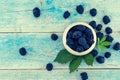 Close up of ripe blackberries in a white ceramic bowl over rustic wooden background. Top view Royalty Free Stock Photo