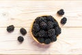 Close up of ripe blackberries in a white ceramic bowl over rustic wooden background Royalty Free Stock Photo