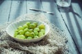 Close up ripe Green fresh gooseberry in ceramic bowl on rustic black wooden kitchen table back lightened by morning light. Farmer