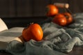 close-up of ripe persimmons next to book on dark table front view Royalty Free Stock Photo