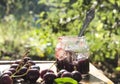 Tasty sweet cherry jam and fresh cherries on the rustic wooden table in the garden