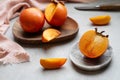 Close-up of ripe Sharon persimmon and slices on plates