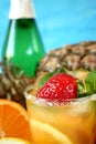 Close-up of a ripe strawberry and mint in the glass with orange drink