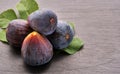 Close up of a ripe sweet fruit figs with green leaves on grey stone Royalty Free Stock Photo