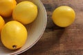 Close-up of ripe yellow lemons in a bowl on wooden table. Flat lay, copy space. Rustic style composition. Royalty Free Stock Photo