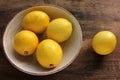 Close-up of ripe yellow lemons in a bowl on wooden table. Flat lay, copy space. Rustic style composition. Royalty Free Stock Photo