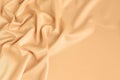 Close up of ripples in gold colored silk fabric. Satin textile background. Royalty Free Stock Photo