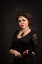 Close up. Roaring Twenties. Woman portrait in the style of Gatsby. Low key. A beautiful young woman in a black dress. Royalty Free Stock Photo