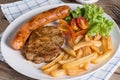 Close up, Roasted beef meat steak and sausage with french fries. Royalty Free Stock Photo