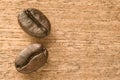 close-up roasted two coffee beans with dark brown color on the wooden table background Royalty Free Stock Photo