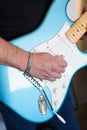 Close-up of a rock musician playing a blue electric guitar and wearing a silver cuff bracelet Royalty Free Stock Photo