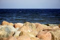 A close up of a rock next to water. Stone beach. Gulf Finland. Blue water. Sea