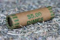 Close up of a roll of dimes bedded on shreds of unfit US currency.