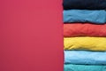Close up of rolled colorful clothes on red background Royalty Free Stock Photo