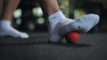 Close-up. Rolling a ball with your feet relieve midfoot discomfort. A man's socked foot rolls a small hard ball