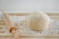 Close-up of rolling pin and dough on wooden table with flour. Basic needs and rising of prices concept Royalty Free Stock Photo