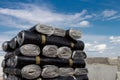 A close-up of rolls of new black roofing felt or bitumen that is precisely folded against a blue sky Royalty Free Stock Photo