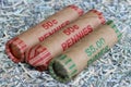 Close up of rolls of pennies and dimes bedded on shreds of unfit US currency.