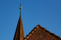 Close up of a rooftop and a church spire against clear blue sky Royalty Free Stock Photo